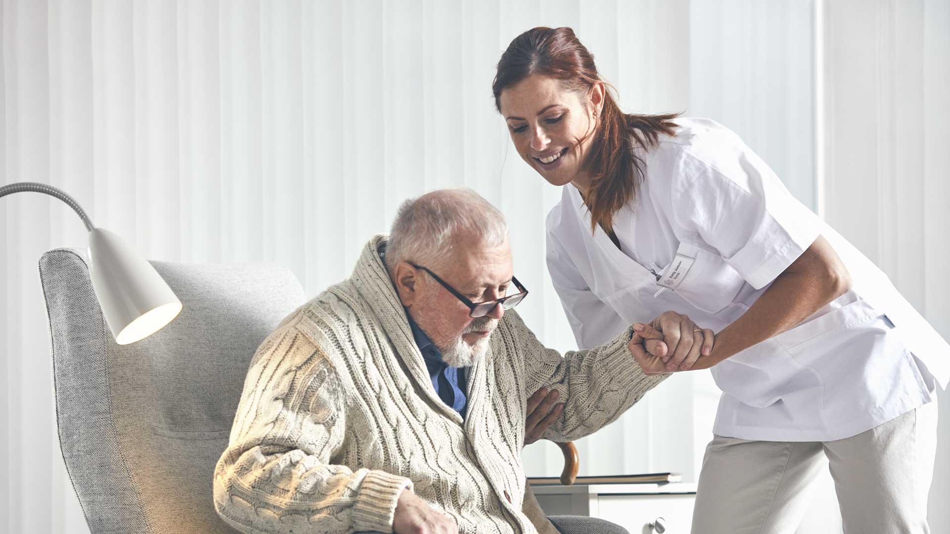 Namų slaugos slaugytoja, prižiūrinti pagyvenusį pacientą
