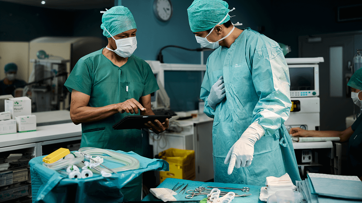 A photo of two surgeons discussing the contents of a surgical tray.