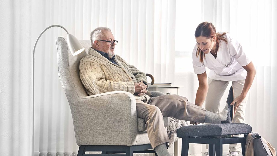 Health care professional helping an elderly man