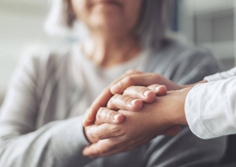 Health care professional holding patient's hand