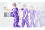 kvinnelig sykepleier iført Barrier operasjonsbekledning på vei inn i rommet